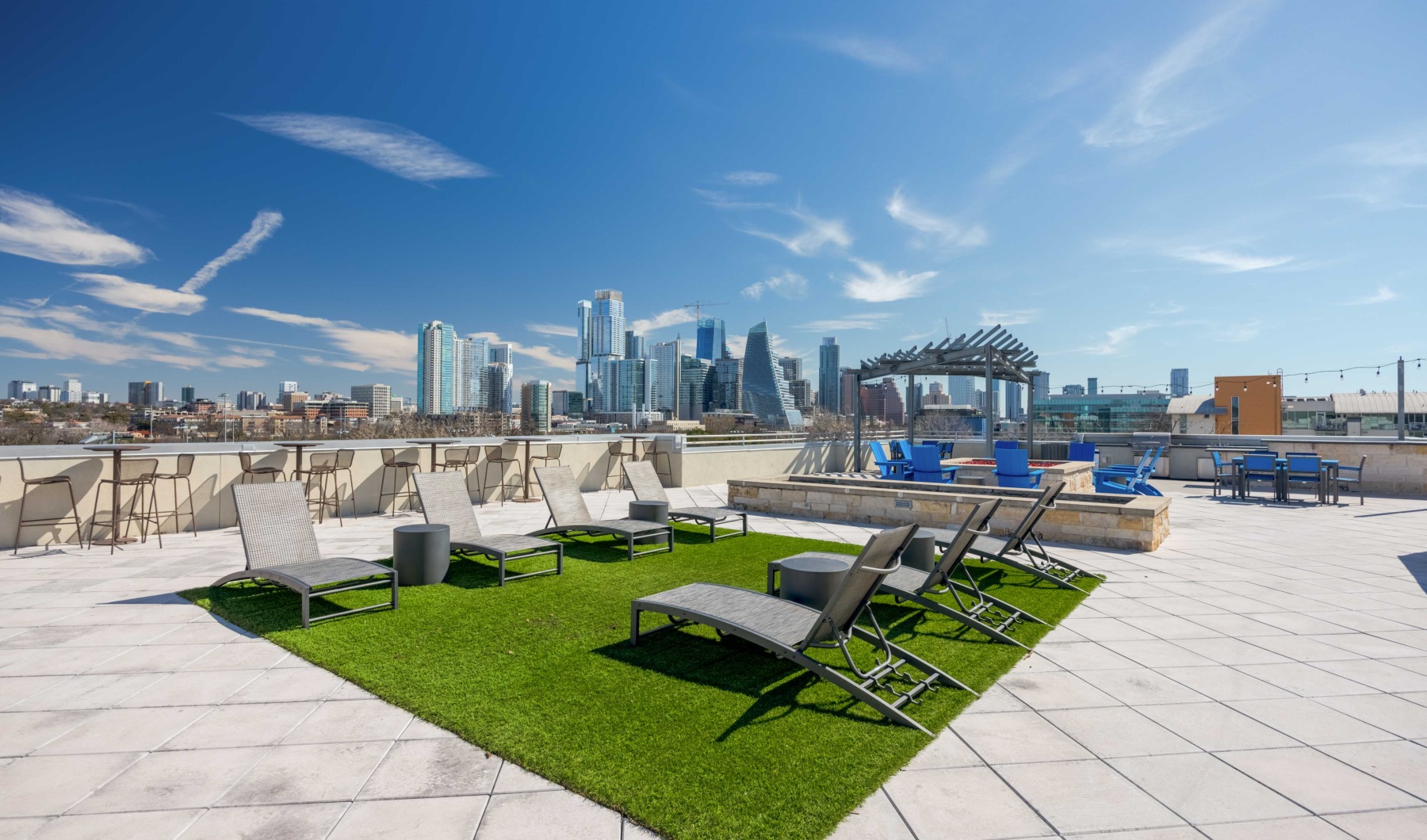 a patio with chairs and tables and a city skyline in the background