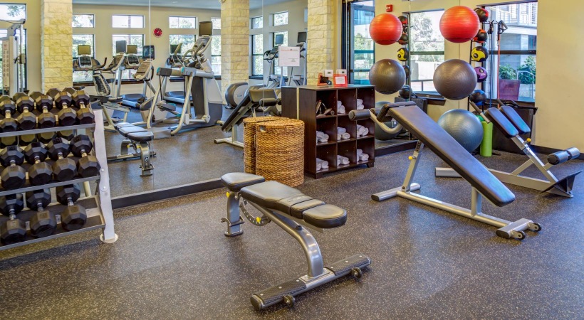 State-of-the-art amenities a room with exercise equipment and chairs